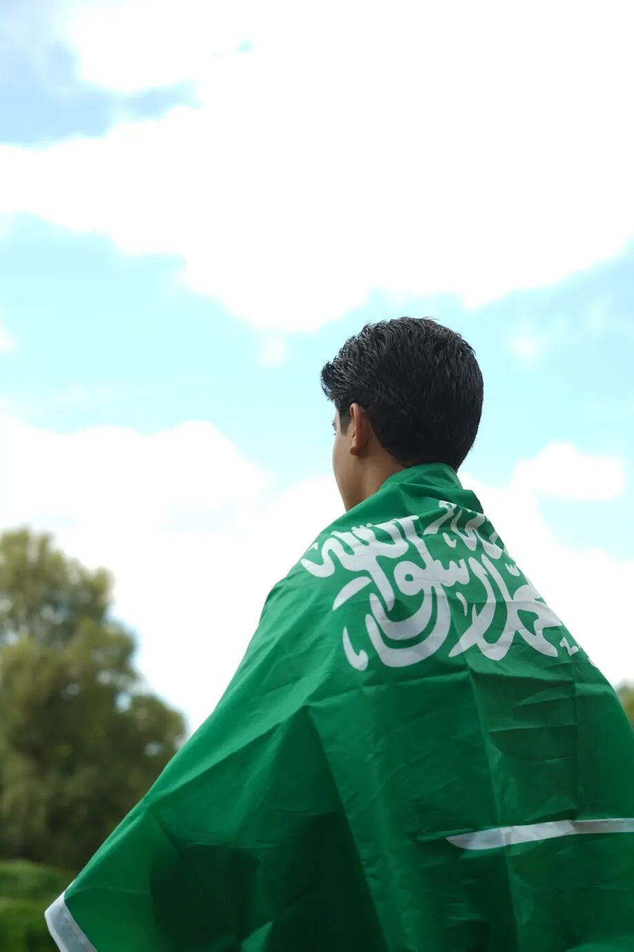طالب يلتف بالعلم السعودي